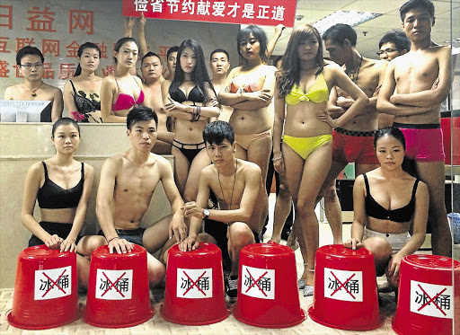 COLD COMFORT: Youths in Shenzhen, China prepare for a strip-off challenge in opposition to the water-wasting ice-bucket rage