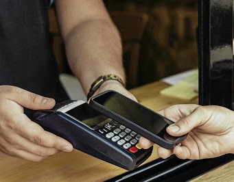 A customer makes a payment with her smartphone, enabling her to avoid touching a point-of-sale device to enter her PIN. Picture: 123rf.com