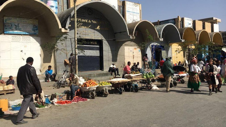 Many businesses in central Mekelle are shuttered but people are selling fruit and vegetables in front of them