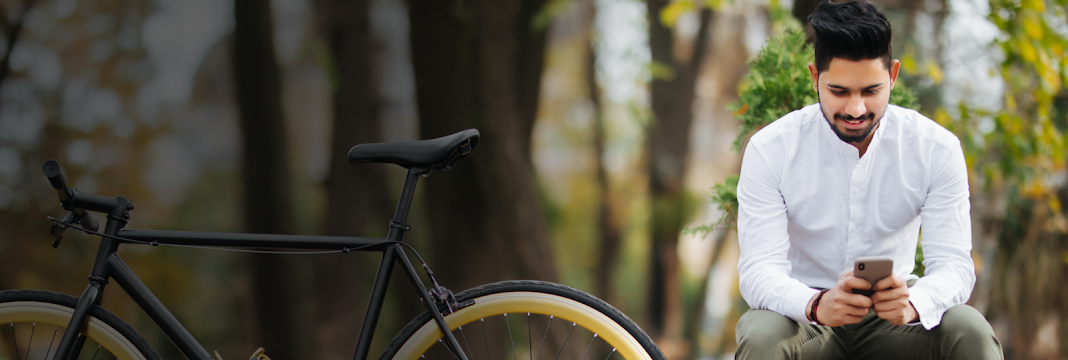 A man with a bicycle looking at his phone