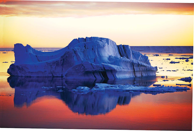 A tabular iceberg in Antarctica at sunset, seen during a Lindblad Expeditions tour.
 