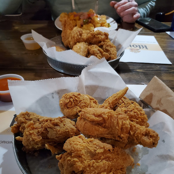 Original half order of fried chicken in front, 10 piece wings behind