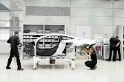 FUTURE TECH: Left, the wind tunnel. Right, crew working on the MP4-12C at the Production Centre