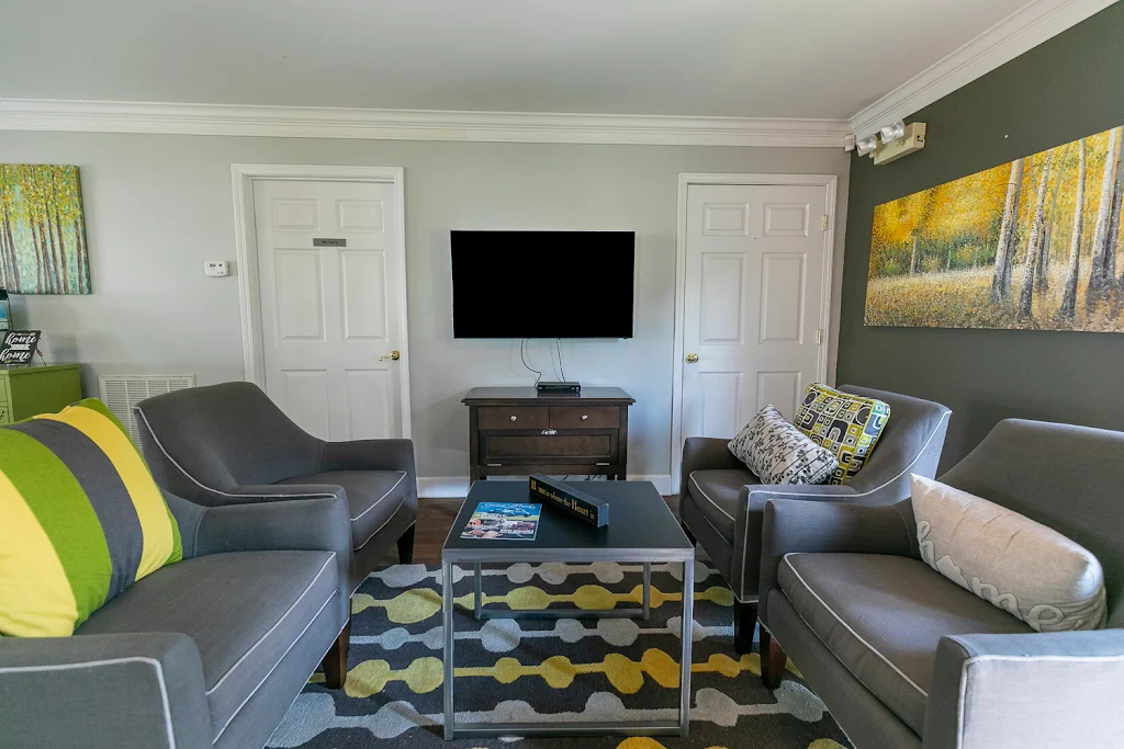 Clubhouse lounge area with dark gray chairs and TV