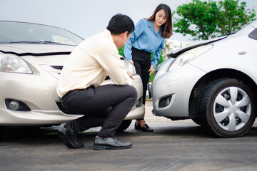 Two drivers check for damage after a car accident before taking pictures and sending insurance. Online car accident insurance claim idea after submitting photos and evidence to an insurance company.