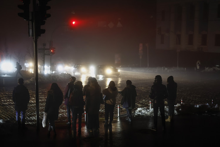 Residents walk through an unlit street in Kyiv, Ukraine on November 24 2022 following missile strikes. Kyiv and several other cities were hit by another wave of Russian missile strikes, further damaging the country's energy infrastructure and other utilities. Picture: Jeff J Mitchell/Getty Images