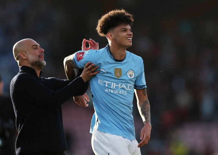 Manchester City manager Pep Guardiola celebrates with substitute Nico O'Reilly, who provided both assists, after their FA Cup quarterfinal win against AFC Bournemouth at Dean Court in Bournemouth on Sunday. Picture: REUTERS/HANNAH McKAY