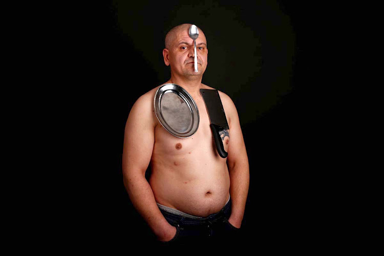 Nermin Halilagic, 38, poses with kitchen utensils in Bihac, Bosnia and Herzegovina January 23, 2017. Halilagic discovered earlier this year that he had the unusual ability to attach items to his body using what he says is a special energy radiated from his body. Without making any special preparation, he says he is able to hold on to spoons, forks, knives, and other kitchen appliances, as well as non-metal objects like remote controls, all plastic stuff, and cell phones.