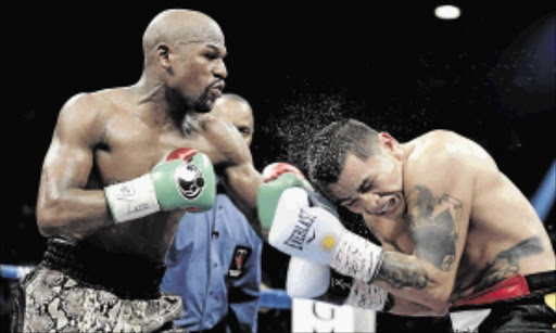 IN CONTROL : Floyd Mayweather slams a left hook to the head of Marcos Maidana during their clash at The MGM Grand in Las Vegas Photo: John Gurzinski/AFP