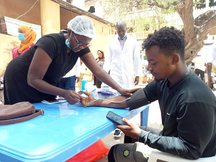 Lamu nurse Connie Zighani takes the blood pressure vital of Abdulali Karimjee at Mkunguni square in Lamu island.
