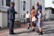 The Cambridges are greeted by headmaster Jonathan Perry as the children prepare for a settling-in afternoon at Lambrook School.