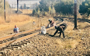 People scour the gravel along the railway lines for any bit of coal they can find.