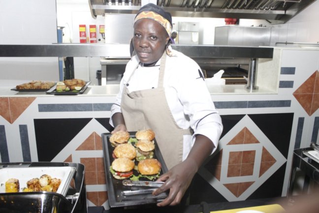 Chef Josephine Mbithe displays hamburgers straight from the oven