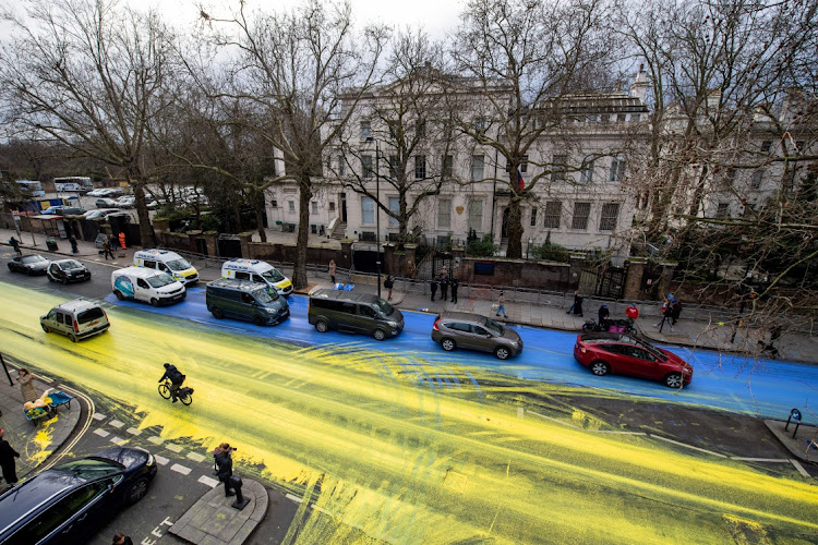 Activists from political campaign group Led By Donkeys pour paint onto the road to create a giant Ukrainian flag outside the Russian Embassy on February 23 2023 in London, England. Picture: HANDOUT/LED BY DONKEYS VIA GETTY IMAGES