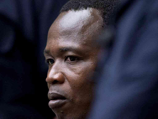 Dominic Ongwen, a senior commander in the Lord's Resistance Army, whose fugitive leader Kony is one of the world's most-wanted war crimes suspects, is flanked by two security guards as he sits in the court room of the International Court in The Hague, Netherlands, December 6, 2016. /REUTERS