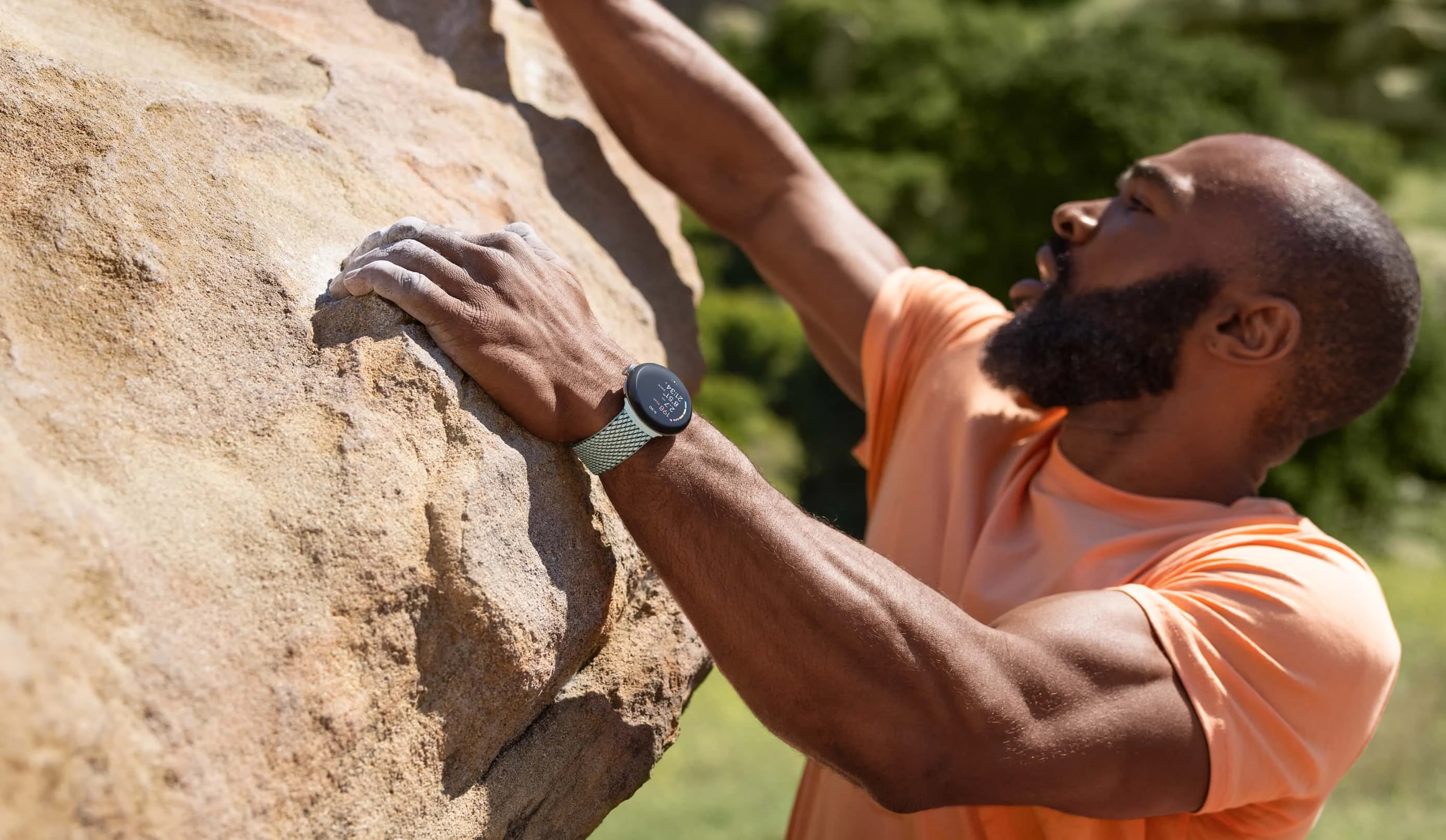 A person rock climbs while wearing a Google Pixel Watch 2, which has safety features that can help in an emergency.