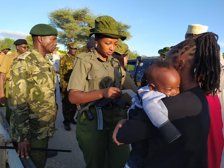 A police officer at the Garissa Tana bridge goes through the documents of a traveler on Saturday.