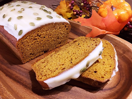 A beautiful pumpkin-chai bread topped with icing and pumpkin seeds