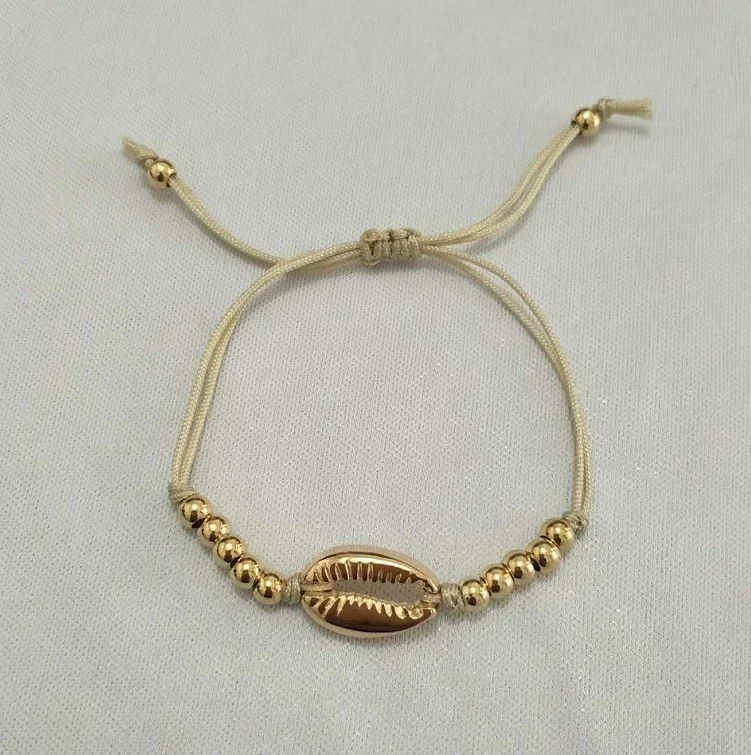 Pulseira de concha tecida com contas redondas para as férias, um acessório leve e elegante para um visual praiano e descontraído.