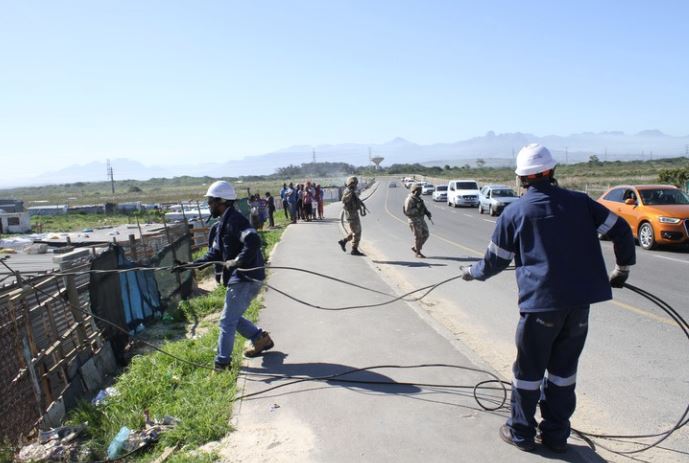 Eskom employees removing illegal connections from Qandu-qandu informal settlement in Khayelitsha under the protection of police and SANDF members.