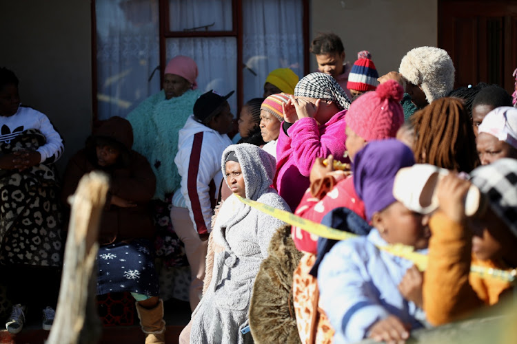 Residents and family members outside the tavern in Scenery Park where 21 people died in the early hours of Sunday morning in East London. Police minister Bheki Cele says the partygoers died between 2.13am and 4am.