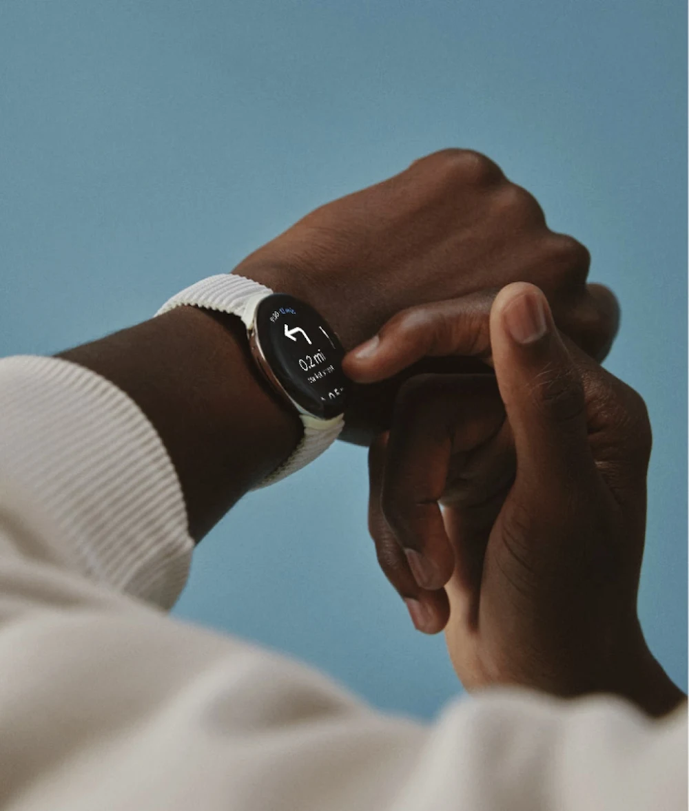 A hand touches the screen on the Google Pixel Watch on their wrist