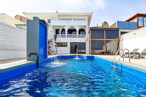 Buy this luxury chalet in Candelaria (Spain) - Outdoor pool with waterfall and lounge chairs