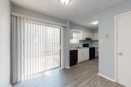 Dining room with wood-inspired flooring and view of the kitchen