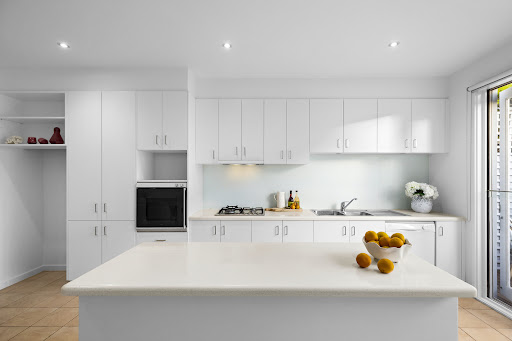 Cuisine moderne blanche avec îlot central dans cette Maison de luxe à vendre à Albert Park