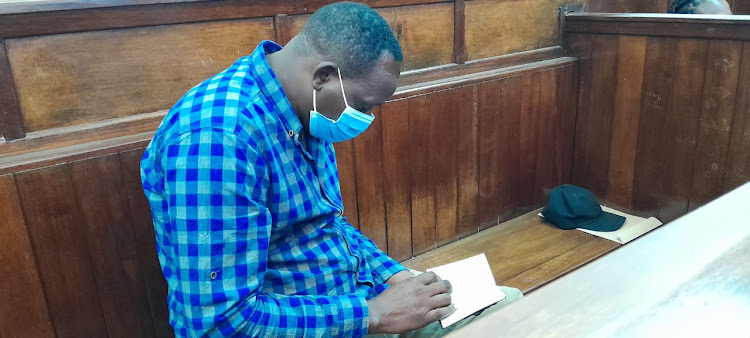 Suspect Ibrahim Rotich reading the bible while in court.