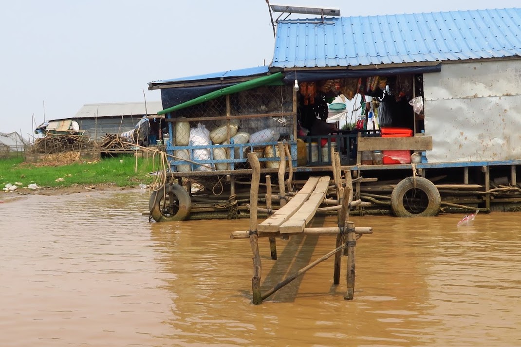 A floating provision store moored on the shore of the stream. 