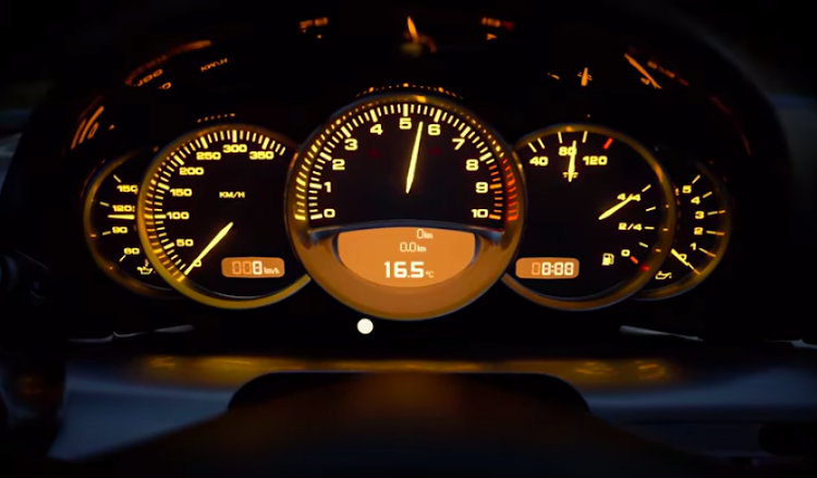 The trailer features a close up of a Porsche Carrera GT instrument cluster. Do the math...