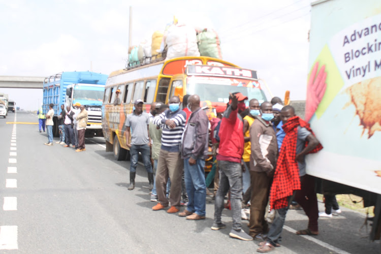 Passengers stranded after a PSV vehicle they were travelling in was inmpounded during the ongoing Rapid Results Initiative crackdown on moto vehicles along Nairobi - Mombasa highway in Athi River, Machakos County on Friday, February 25, 2022.