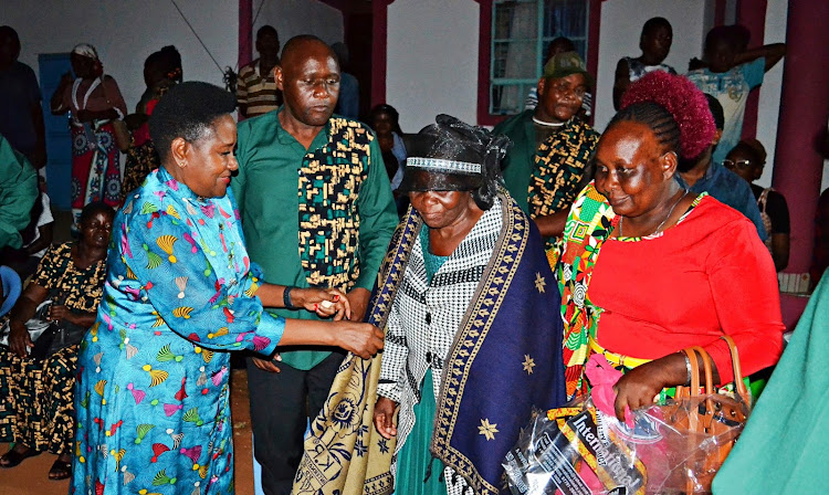 Nominated Senator Beth Syengo gifts matriarch Lydia Kalekye with a lesso during the Saturday celebration at Itivanzou village, Mwingi North of Kitui County.