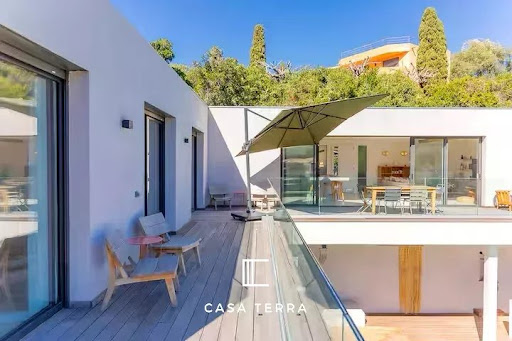 Wooden terrace with modern outdoor furniture in this luxury villa for sale in Sainte lucie de porto vecchio ($1,591,155 - 150 m²)