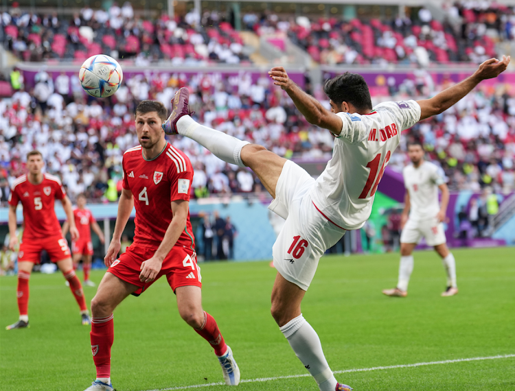 -- Mehdi Torabi (R) of Iran competes during the Group B match between Wales and Iran at the 2022 FIFA World Cup at Ahmad Bin Ali Stadium in Al Rayyan, Qatar, Nov. 25, 2022. (Xinhua/Meng Dingbo)