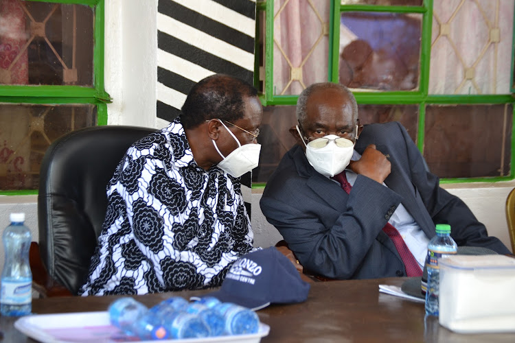 Wiper leader Kalonzo Musyoka consults with his party former chairman David Musila during the burial ceremony at Maai village in Mwingi central Kitui county on Saturday.