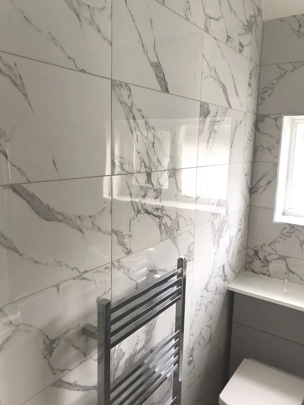 Marble vein tiles with porcelanosa tiled floor, shale grey vanity 