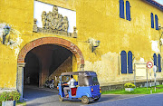 A tuk tuk heads through the Old Gate of Galle Fort in Galle.