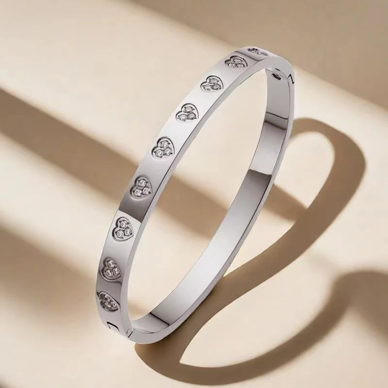 Bracelet romantique en acier titane en forme de cœur avec diamants pour femme, symbole d'amour et d'élégance.