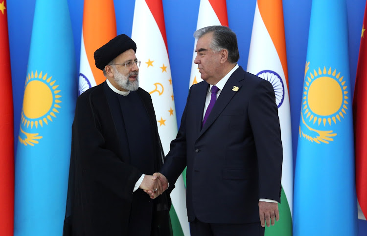 Tajik President Emomali Rakhmon shakes hands with Iranian President Ebrahim Raisi during the Shanghai Co-operation Organisation summit in Dushanbe, Tajikistan, September 17 2021. Picture: REUTERS/DIDOR SADULLOEV