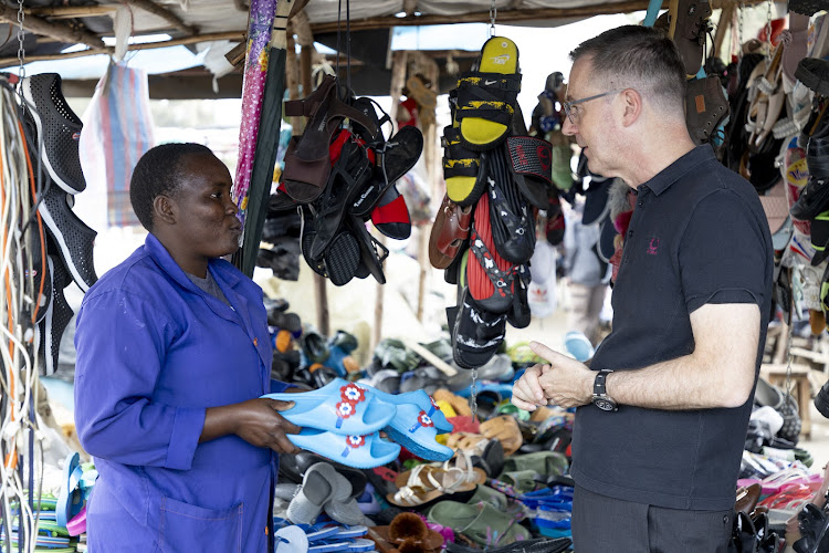 IFC Vice President for Africa Sérgio Pimenta meets with small business owner Francisca Endoli. Endoli uses M-KOPA, an IFC investee, to help grow her business.