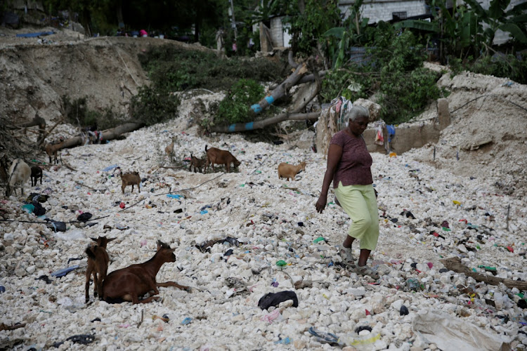 A woman walks next to fallen trees in an area affected by the passage of Tropical Storm Laura, in Port-au-Prince, Haiti August 25 2020. Picture: REUTERS/ANDRES MARTINEZ CASARES