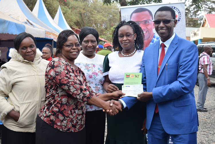 Ruiru MP Simon King'ara presents a cheque to one of the groups that benefited from Sh5 million Women Enterprise Fund disbursed in Ruiru town