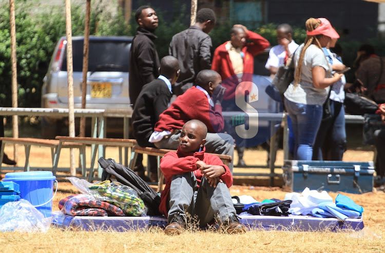 A newly admitted Form One student sitting with his belongings at Dagoretti Boys High School in Nairobi on February 6,2023.