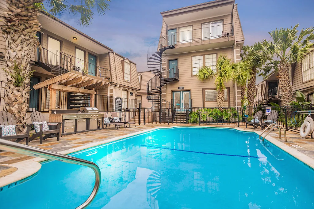 Legends of Memorial apartment buildings with view of pool at dusk