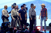 Jason Aldean (R) and radio personality Bobbie Bones honor first responders of the Oct 1, 2017 Las Vegas mass shooting during the iHeartRadio Music Festival at T-Mobile Arena in Las Vegas, Nevada, US, September 21, 2018. 