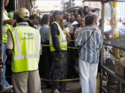 ILLEGAL ACTIVITIES: Sars custom officials and police check the trademark certificates of inner-city hawkers after a raid yesterday on a block of flats that has been converted into a shopping mall. 19/11/08. Photo: Kgotso Makaane. © Unknown.