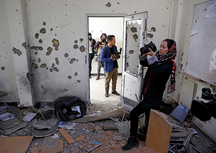 Afghan journalists film inside a classroom after yesterday's attack at the university of Kabul, Afghanistan November 3, 2020.