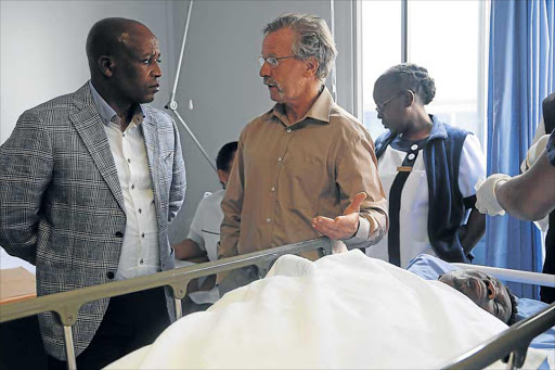 CREATING AWARENESS: Premier Phumulo Masualle,left, with Dr Norrie Gibson during the premier’s visit to Bongani Vumbela, a blind resident from Dimbaza who was hit by a car last Saturday Picture: SIBONGILE NGALWA